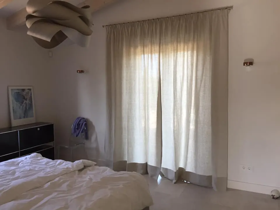 Cortina de lino natural con bajo en contraste en dormitorio