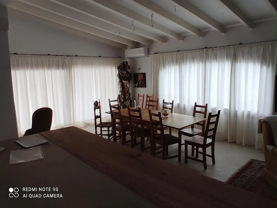Cortinas blancas confeccionadas a medida en comedor con vigas vistas