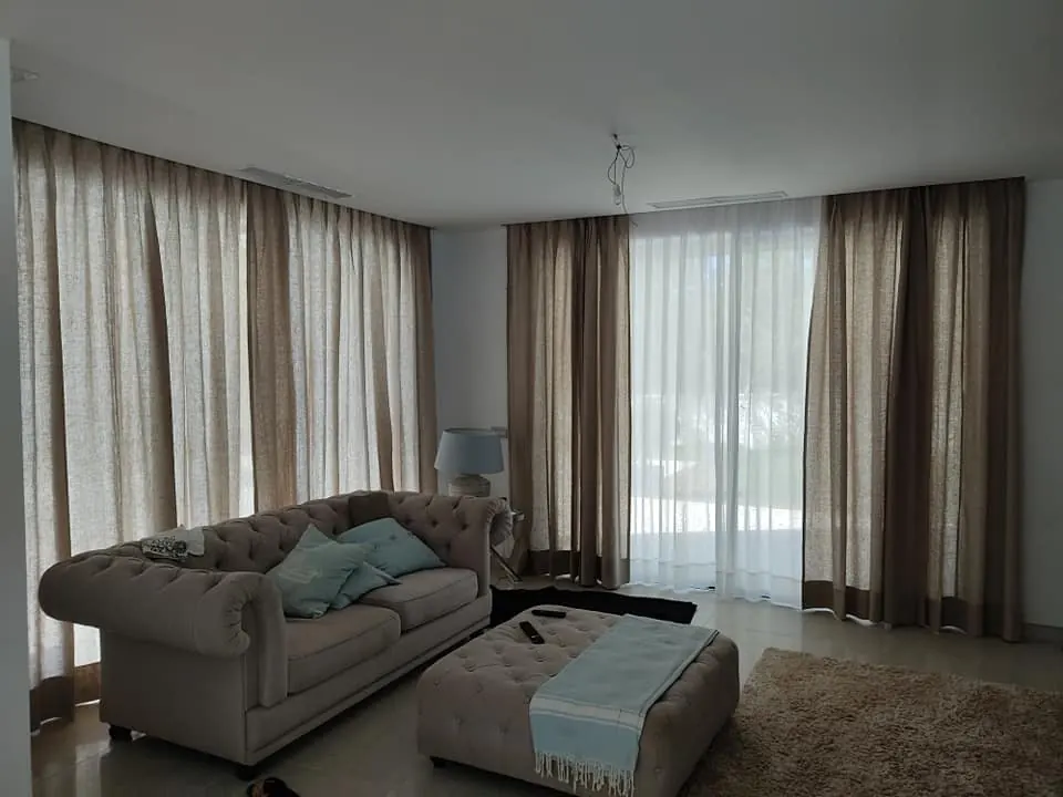 Cortinas de lino a medida en salón con sofá chester en Mallorca