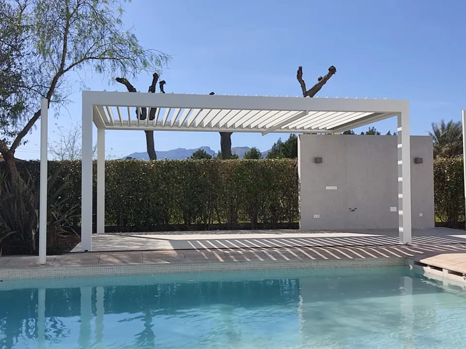 Pérgola bioclimática de lamas orientables instalada en un jardín de Mallorca