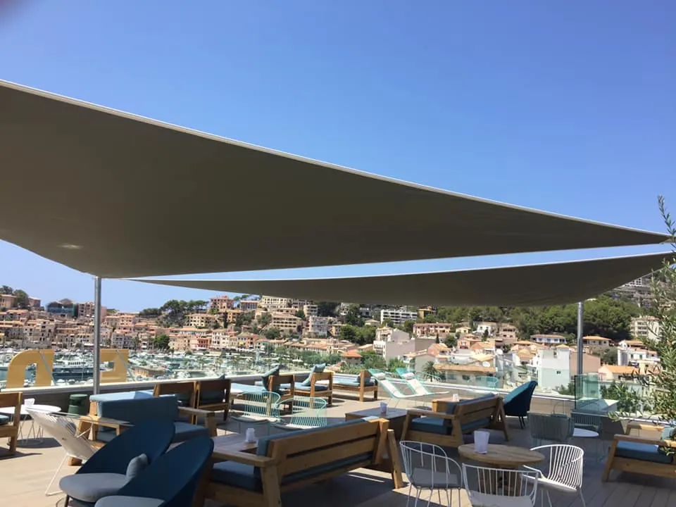 Velas tensadas color arena sobre terraza lounge de hotel en Mallorca